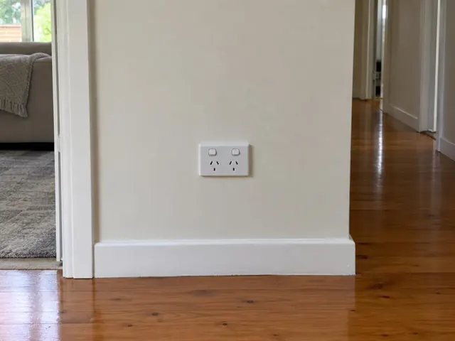 Double power point on a painted hallway wall above white skirting and timber floor in Wyoming
