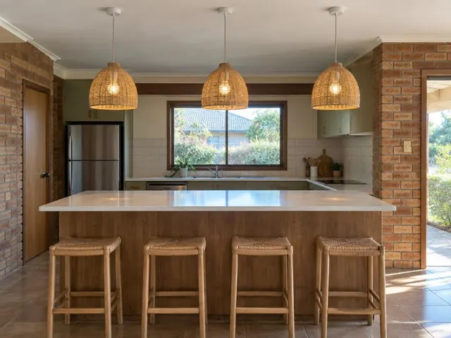 Three woven pendant lights above a kitchen island in a brick home interior in Lisarow